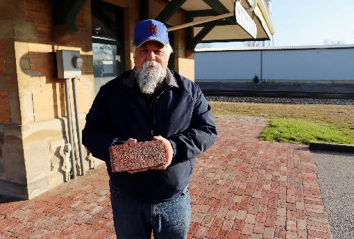 Stryker depot west side looking south with Bruce Zigler holding brick from walkway Dec 2020 Stryker depot west side looking south with Bruce Zigler holding brick from walkway Dec 2020